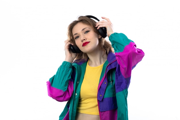 Hermosa mujer joven en chaqueta colorida y con auriculares