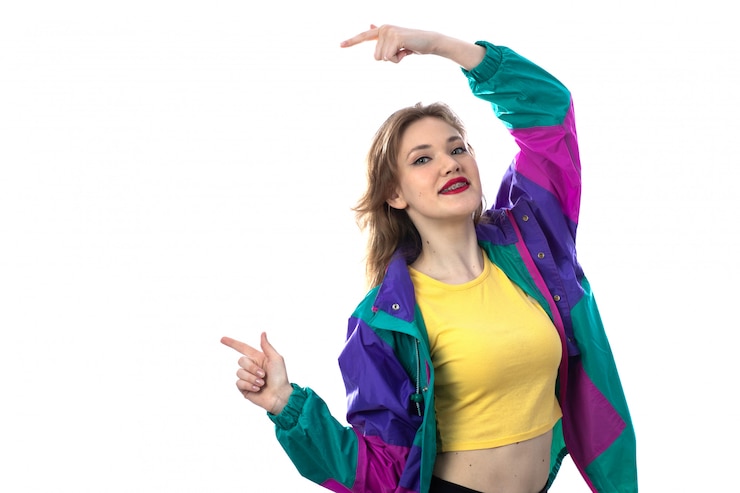 Foto gratuito hermosa mujer joven en chaqueta colorida señalando