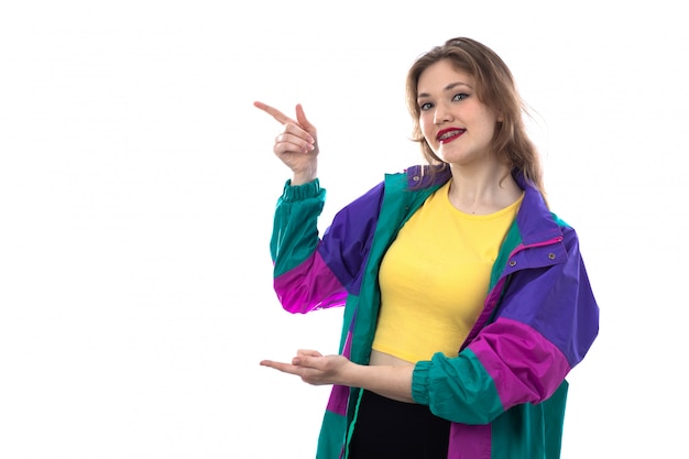 Hermosa mujer joven en chaqueta colorida señalando