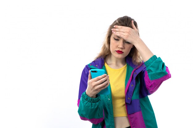 Hermosa mujer joven en chaqueta colorida y con smartphone