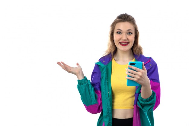 Hermosa mujer joven en chaqueta colorida con smartphone