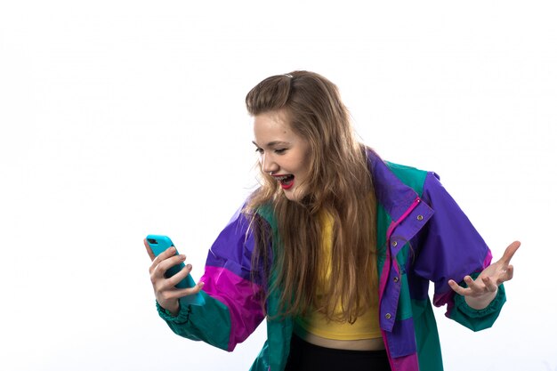 Foto gratuita hermosa mujer joven en chaqueta colorida con smartphone