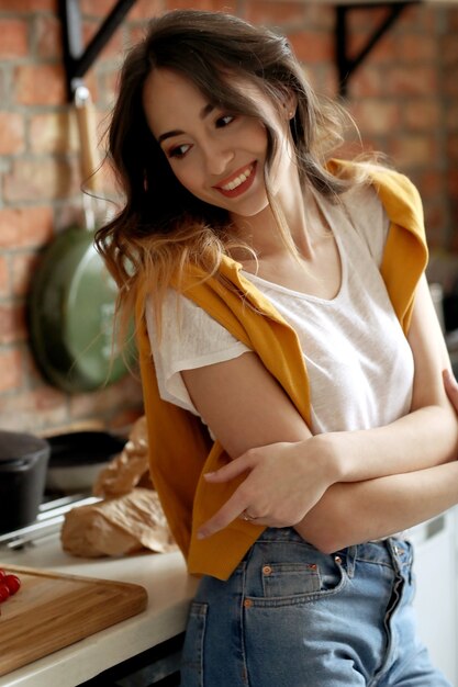 Hermosa mujer joven en la cocina