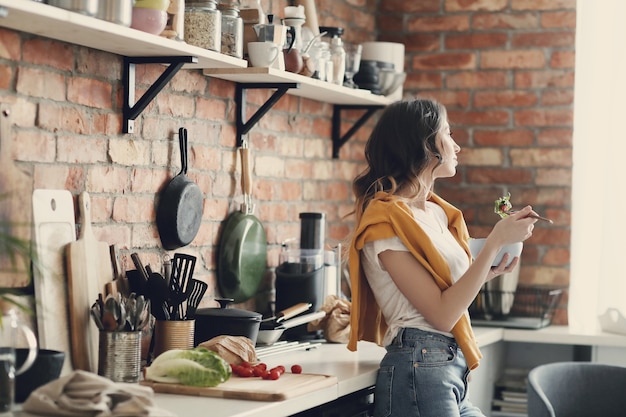 Hermosa mujer joven en la cocina