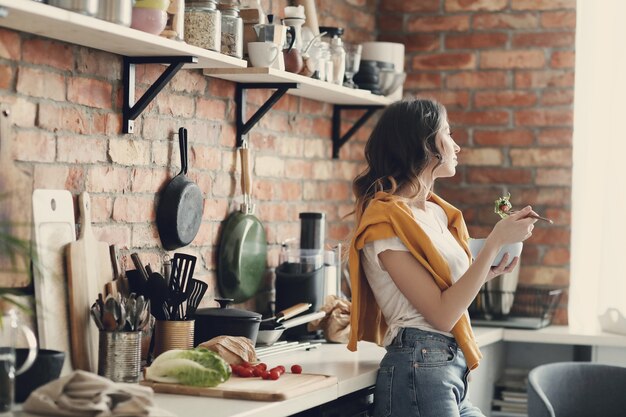 Hermosa mujer joven en la cocina