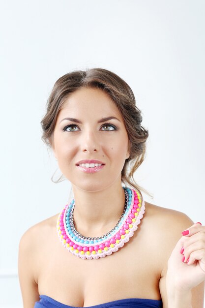 Hermosa mujer joven con collar colorido y pensamiento