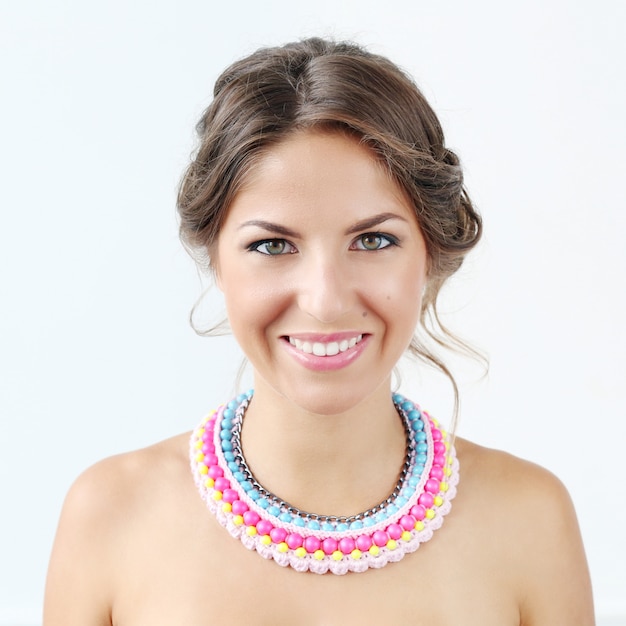 Foto gratuita hermosa mujer joven con collar colorido y sonriente