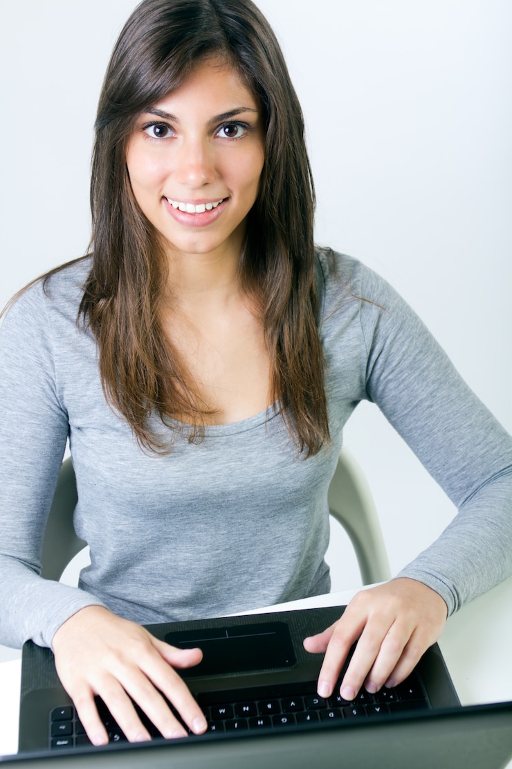 Foto gratuito una hermosa mujer joven con una computadora portátil en el estudio