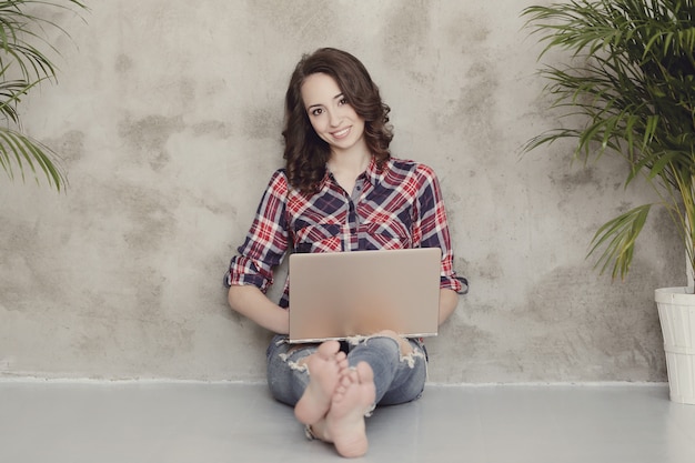 Hermosa mujer joven con computadora portátil