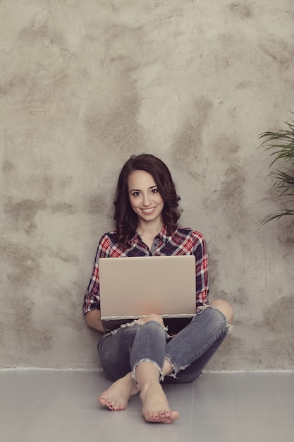 Hermosa mujer joven con computadora portátil