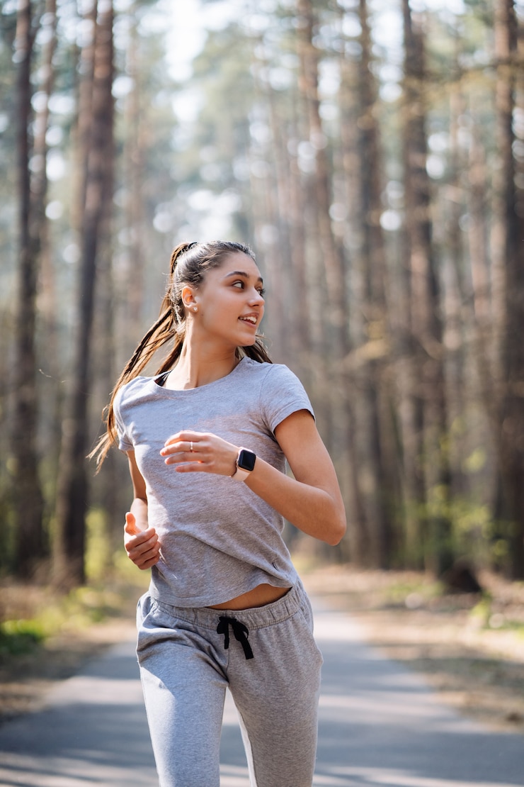 Foto gratuito hermosa mujer joven corriendo en el parque verde en un día soleado de verano