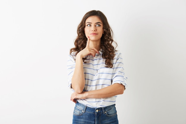 Hermosa mujer joven, expresión de la cara concentrada, pensando en el problema, estilo hipster adolescente, vestida con jeans, camisa, aislado sobre fondo blanco, moda moderna, preocupado, ocupado