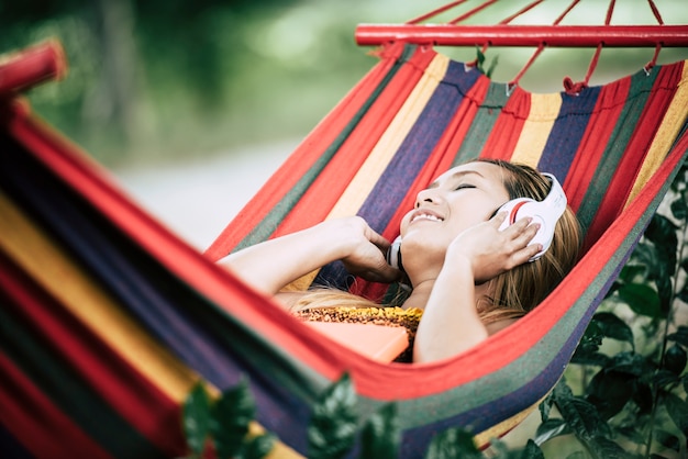 Hermosa mujer joven feliz con auriculares escuchando música