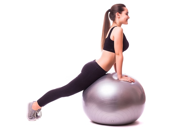 Hermosa mujer joven fitness con ejercicio de pelota de gimnasia, aislado sobre fondo blanco.