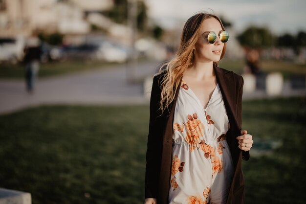 Hermosa mujer joven en gafas de sol en la ciudad