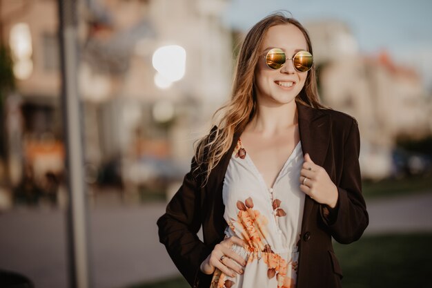 Hermosa mujer joven en gafas de sol en la ciudad