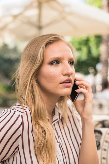 Foto gratuita hermosa mujer joven hablando por teléfono celular