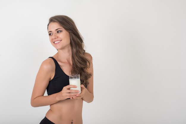 Hermosa mujer joven con leche de vidrio