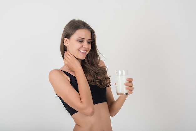 Hermosa mujer joven con leche de vidrio