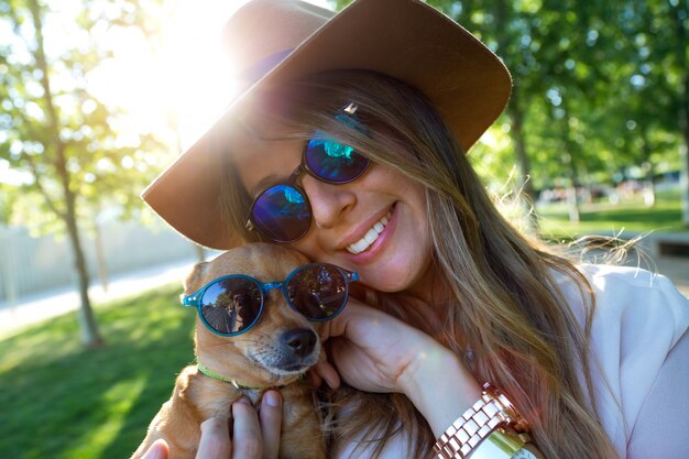 Hermosa mujer joven mirando la cámara con su perro.