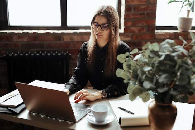 Hermosa mujer joven en la oficina en casa. Trabajando desde casa. Concepto de teletrabajo