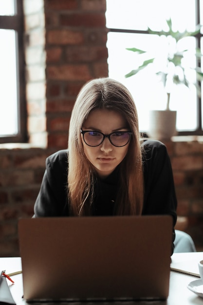 Hermosa mujer joven en la oficina en casa. Trabajando desde casa. Concepto de teletrabajo