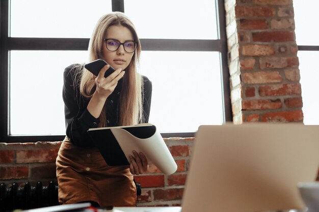 Hermosa mujer joven en la oficina en casa. Trabajando desde casa. Concepto de teletrabajo