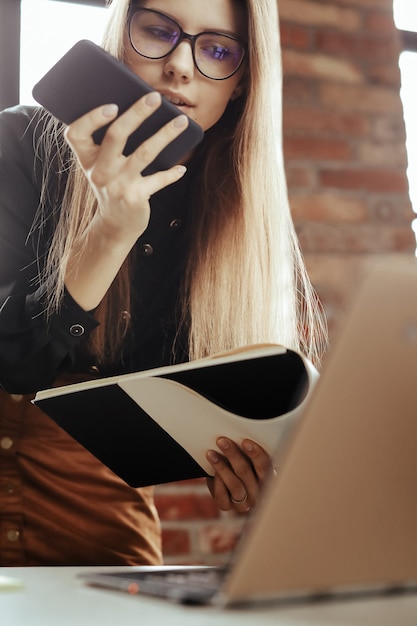 Hermosa mujer joven en la oficina en casa. Trabajando desde casa. Concepto de teletrabajo