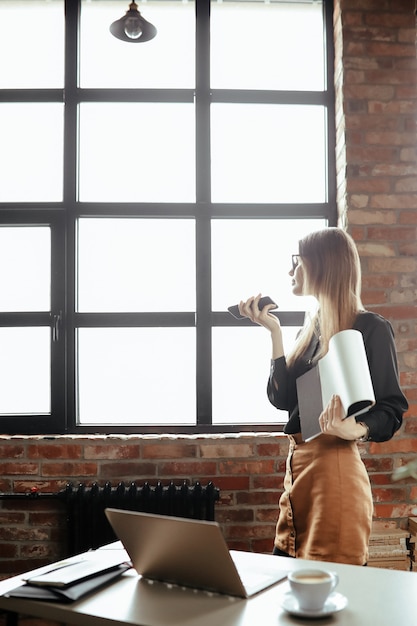 Hermosa mujer joven en la oficina en casa. Trabajando desde casa. Concepto de teletrabajo