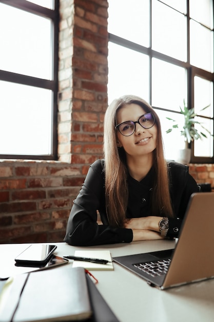 Foto gratuita hermosa mujer joven en la oficina en casa. trabajando desde casa. concepto de teletrabajo