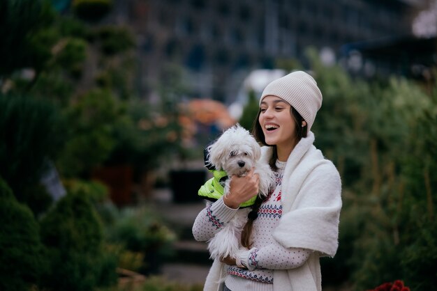 Hermosa mujer joven con un perro blanco