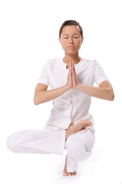 Una hermosa mujer joven en pose de yoga