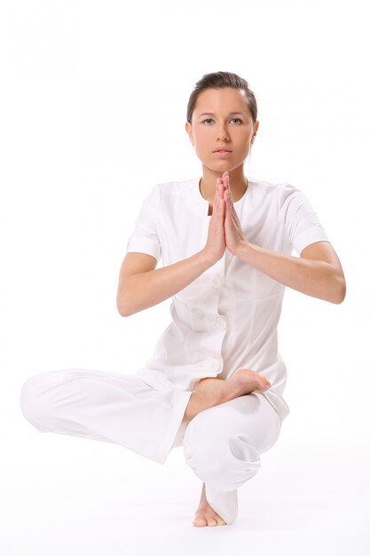 Una hermosa mujer joven en pose de yoga