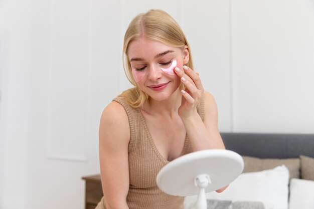 Hermosa mujer joven con un producto para el cuidado facial