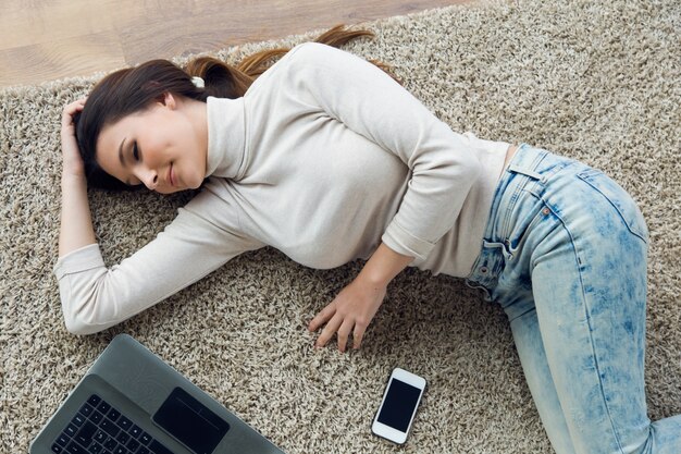 Hermosa mujer joven que trabaja en su computadora portátil en casa.