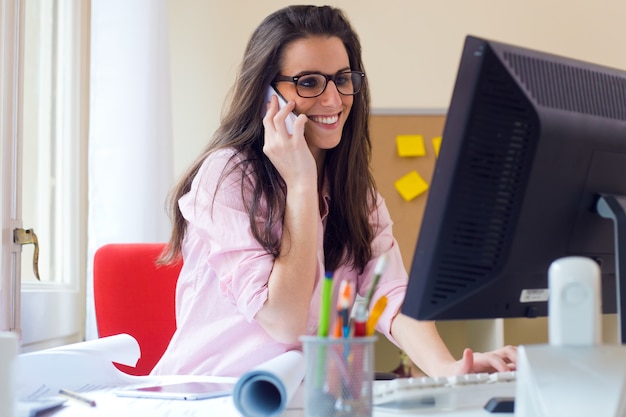 Foto gratuita hermosa mujer joven que trabaja en su oficina.