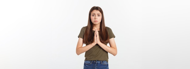 Foto gratuita hermosa mujer joven en ropa casual tomados de la mano y rezando aislado en blanco