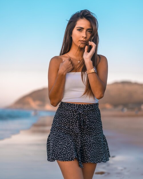 Hermosa mujer joven en ropa casual de verano posando mientras camina en la playa de Zarautz España