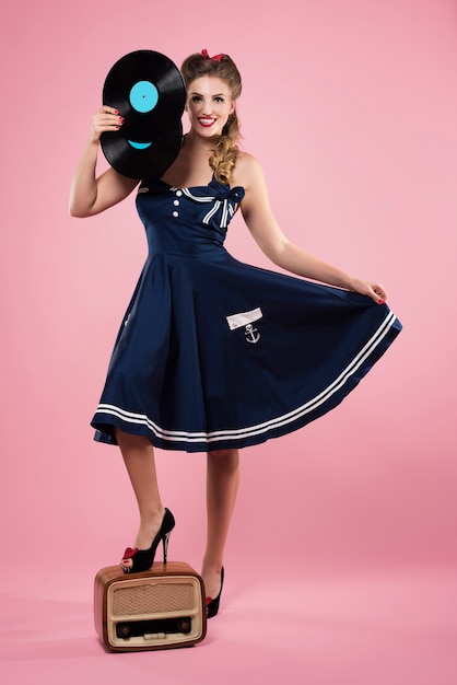 Foto gratuita hermosa mujer joven en ropa de estilo pin-up con vinilos