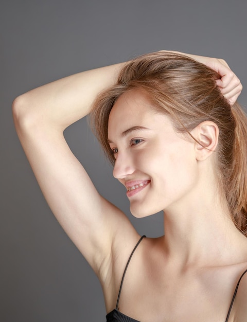 Foto gratuita hermosa mujer joven sonriente con el concepto de belleza natural de la cara de la piel perfecta aislada en el fondo del estudio