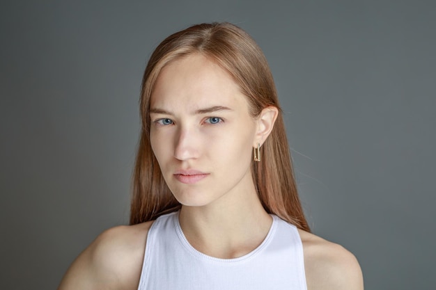 Hermosa mujer joven sonriente con el concepto de belleza natural de la cara de la piel perfecta aislada en el fondo del estudio