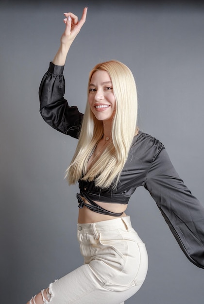 Hermosa mujer joven sonriente con el concepto de belleza natural de la cara de la piel perfecta aislada en el fondo gris del estudio