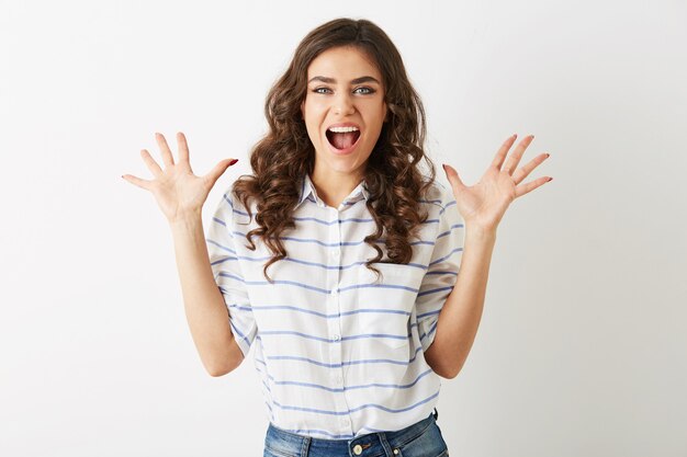 Hermosa mujer joven, sorprendida, estilo hipster adolescente, salió, vestida con camisa, aislada sobre fondo blanco, moda moderna, manos arriba, boca abierta