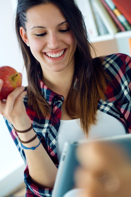 Hermosa mujer joven con su tableta digital en casa.