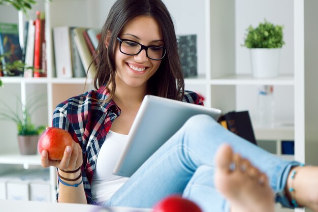 Hermosa mujer joven con su tableta digital en casa.