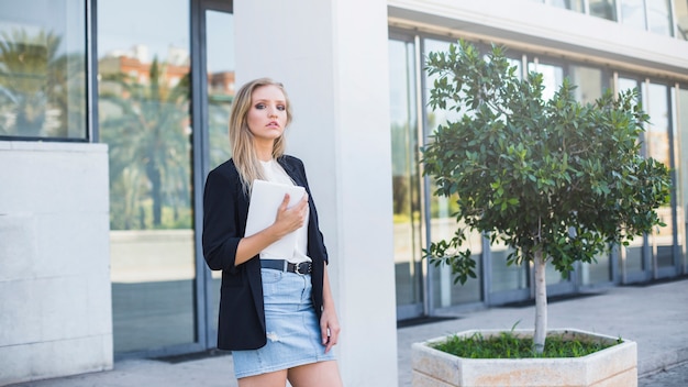 Hermosa mujer joven con tableta digital permanente al aire libre