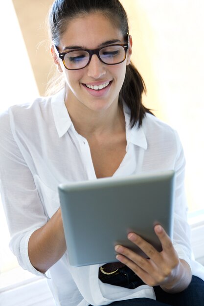 Hermosa mujer joven con la tableta digital