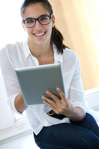 Hermosa mujer joven con la tableta digital