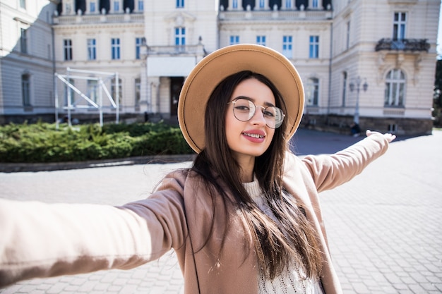 Hermosa mujer joven con tirantes hacen selfie durante un día soleado