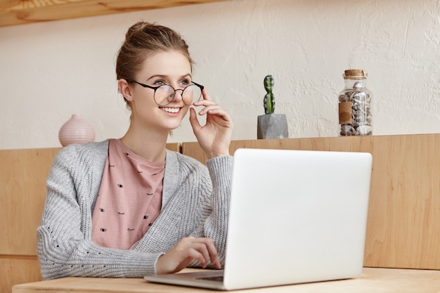 Hermosa mujer joven trabajando con ordenador portátil